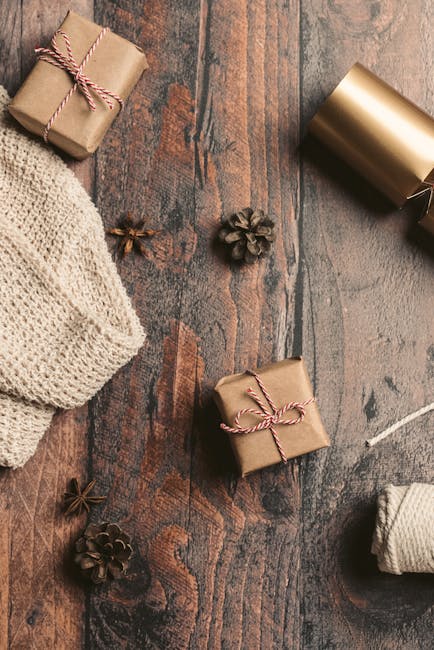 Top view of rustic gift wrapping materials on a wooden surface, including pinecones and twine.